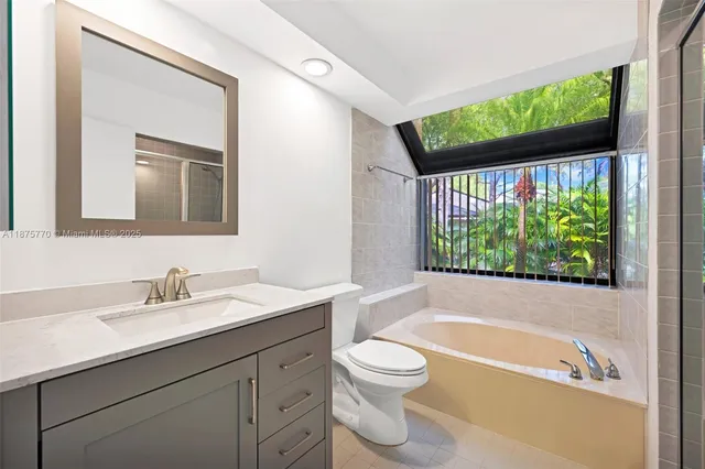 a bathroom with a sink a large mirror and a bathtub