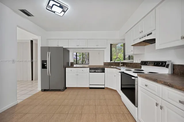 a kitchen with stainless steel appliances granite countertop a refrigerator and a stove top oven
