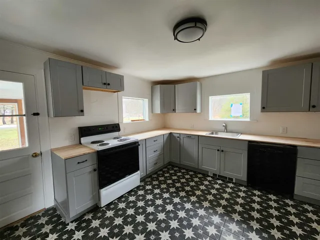a kitchen with a sink and a stove top oven