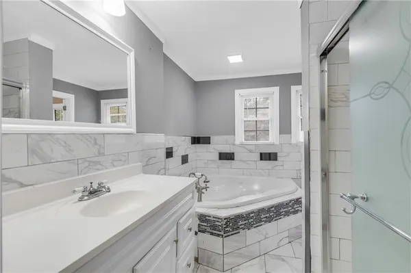 a bathroom with a tub sink and mirror