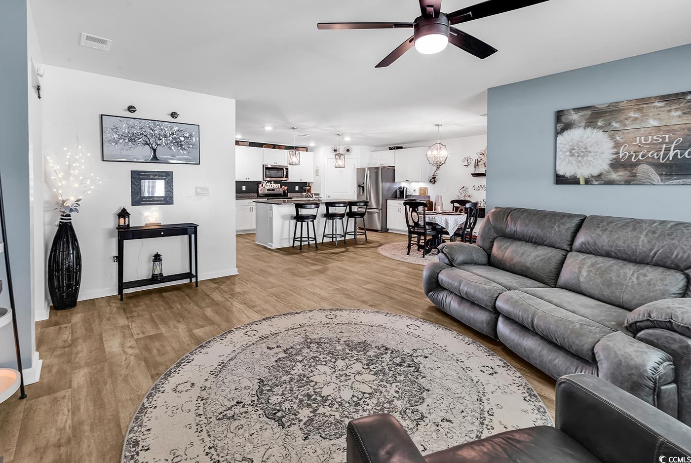 164 Seasons Trace Loop Longs, SC 29568 - Photo 17 of 40 Living room with a ceiling fan, light wood finished floors, and a chandelier