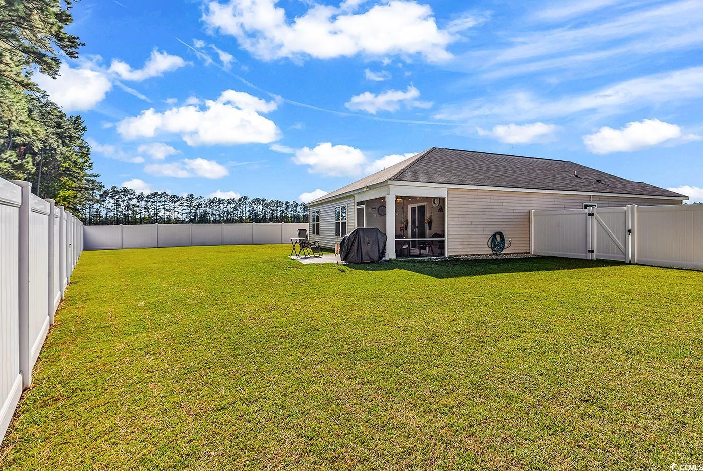 164 Seasons Trace Loop Longs, SC 29568 - Photo 33 of 40 Back of house with a gate, a fenced backyard, a sunroom, and a shingled roof