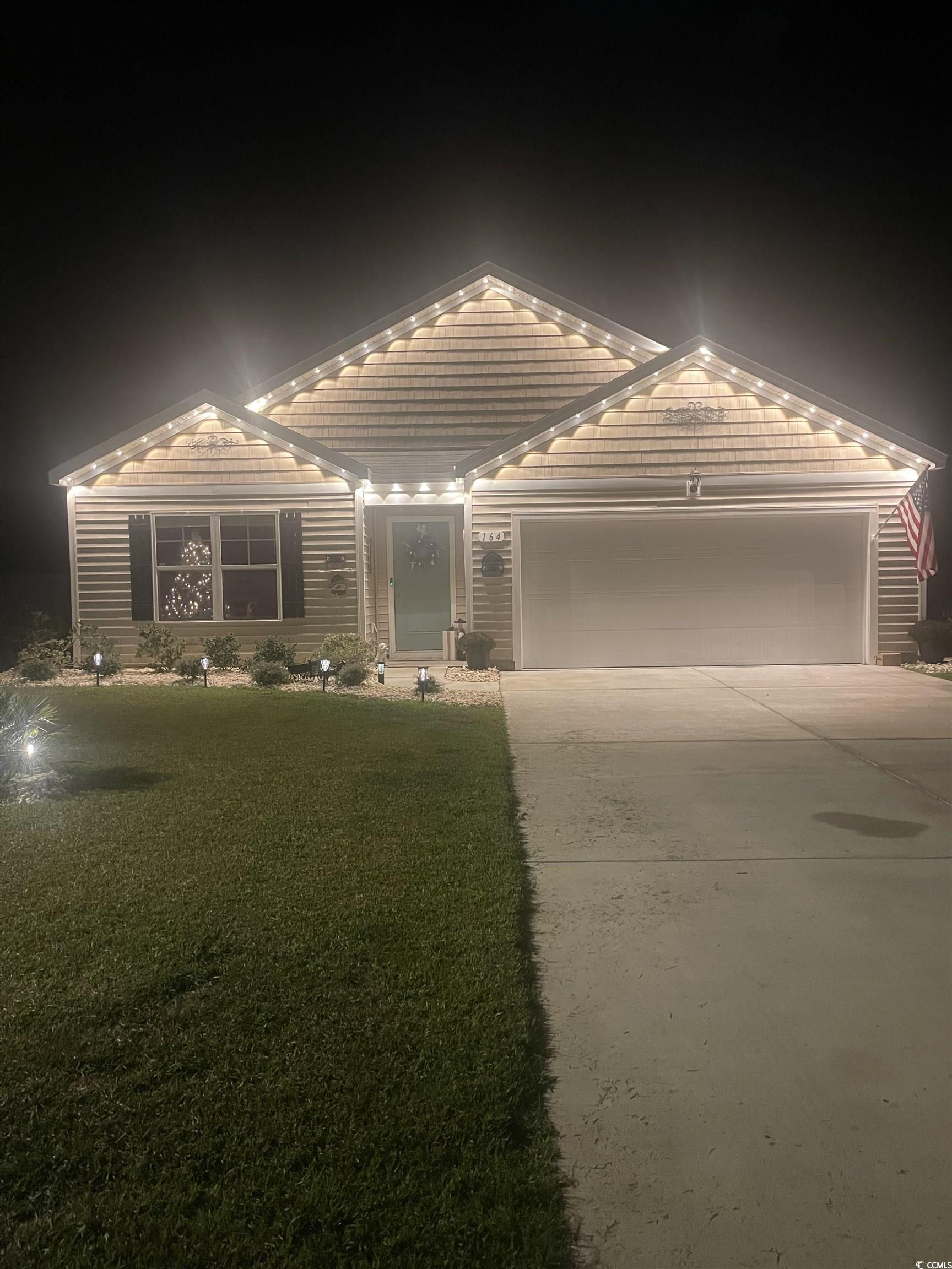 164 Seasons Trace Loop Longs, SC 29568 - Photo 4 of 40 View of front facade featuring a tile roof, concrete driveway, an attached garage, and a front yard