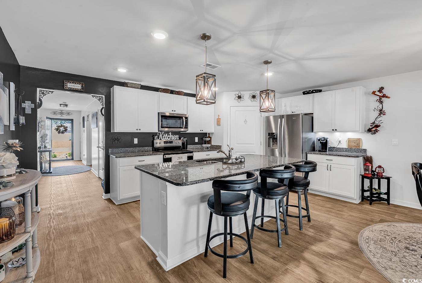 164 Seasons Trace Loop Longs, SC 29568 - Photo 8 of 40 Kitchen with pendant lighting, stainless steel appliances, a kitchen breakfast bar, a kitchen island with sink, and light wood finished floors