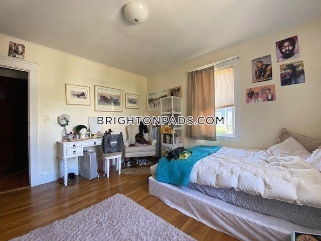 75 Claymoss Road, Unit 1 Boston, MA 02135 - Photo 17 of 25 a bedroom with furniture and a wooden floor