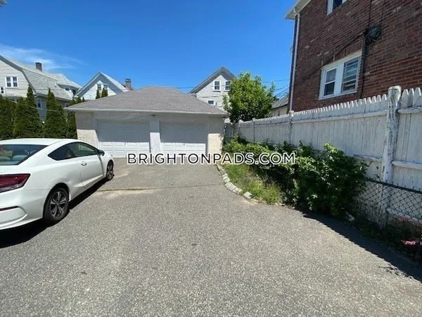 a view of a house with a yard and parking space