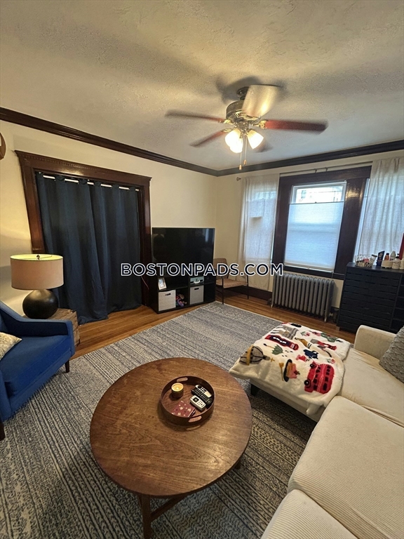 75 Claymoss Road, Unit 1 Boston, MA 02135 - Photo 5 of 25 a bedroom with furniture and a wooden floor