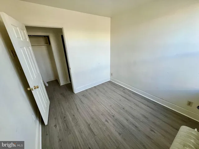 an empty room with wooden floor and entrance