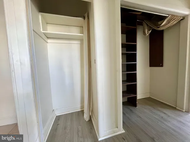 a view of walk in closet with wooden floor