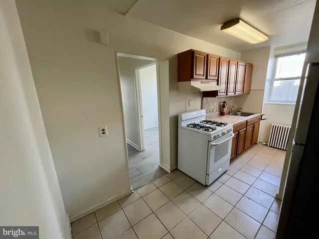 a kitchen with stainless steel appliances a stove top oven a sink a refrigerator and a window