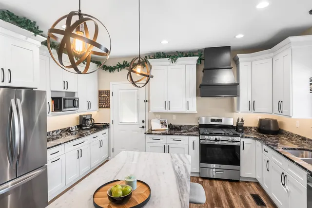 a kitchen with stainless steel appliances a stove a sink and a refrigerator
