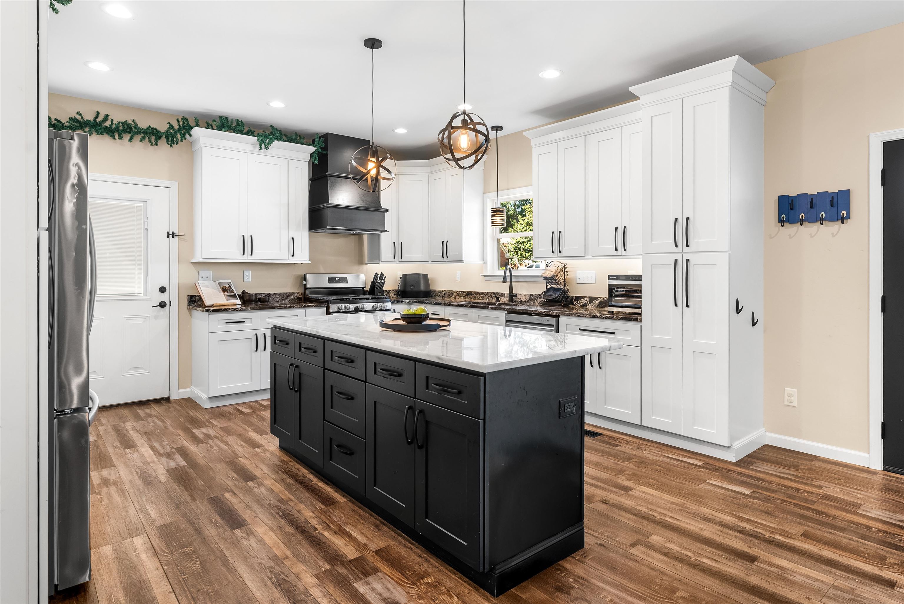 212 South Tipton Street Covington, TN 38019 - Photo 5 of 27 a kitchen with stainless steel appliances granite countertop a sink a stove a refrigerator and a oven with wooden floor