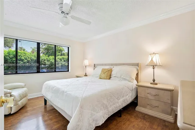 a bedroom with a large bed and a lamp on dresser