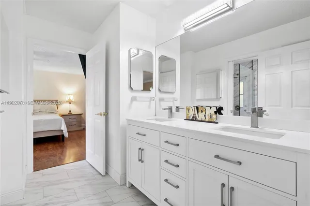 a en suite bathroom with 2 sink flowerpot and a mirror