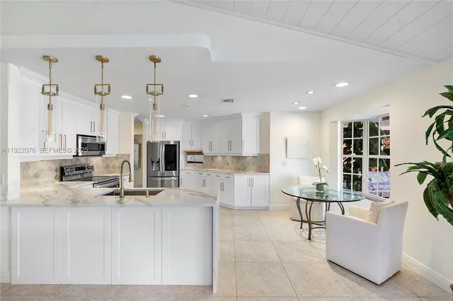 a view of kitchen with kitchen island stainless steel appliances refrigerator stove dining table and chairs