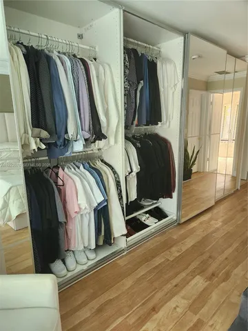 a view of walk in closet with clothes and shoes