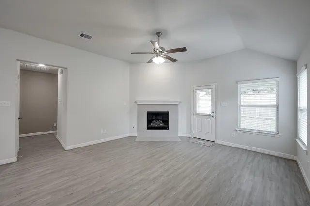 an empty room with windows and a fireplace