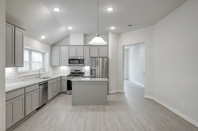 a kitchen with stainless steel appliances granite countertop a sink stove and refrigerator