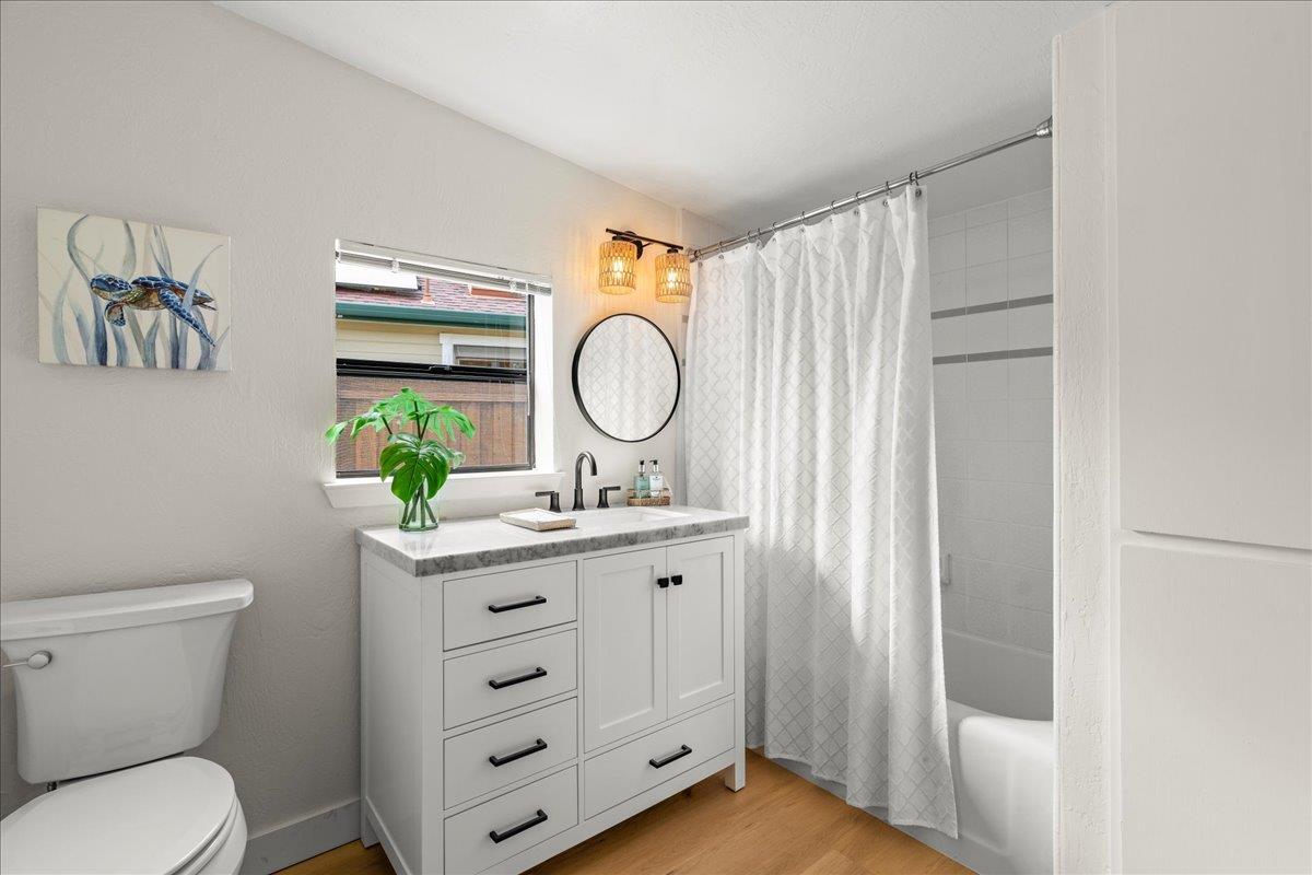 214 Rigg Street Santa Cruz, CA 95060 - Photo 21 of 32 a bathroom with a granite countertop toilet sink and mirror