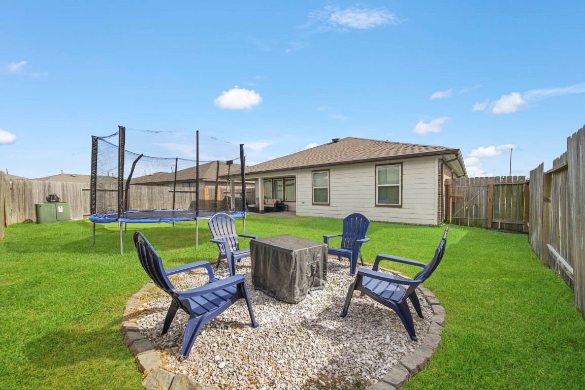 8210 Buck Lane Rosharon, TX 77583 - Photo 28 of 30 Backyard fire pit area with seating, perfect for entertaining and relaxing outdoors.