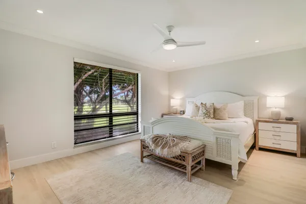 a bedroom with a bed tv and a large window