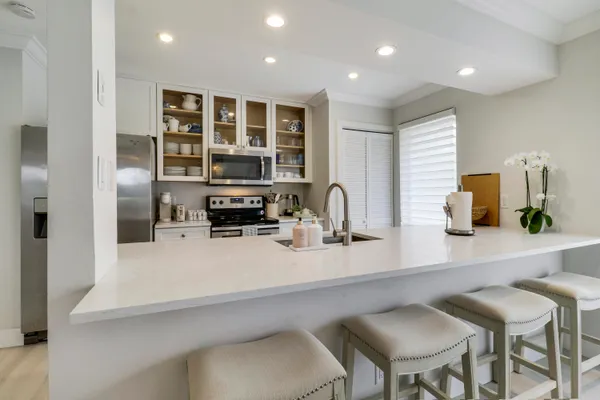 a kitchen with a sink cabinets and chairs