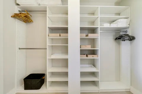 a bedroom with a bed two lamps and a large window