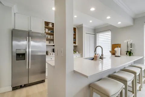 a kitchen with kitchen island a refrigerator and a sink