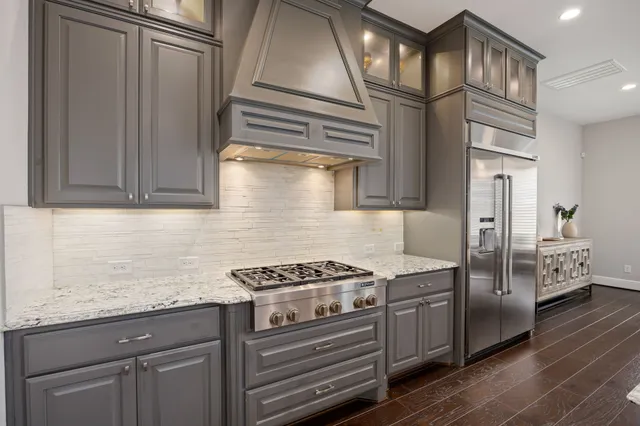 a kitchen with stainless steel appliances granite countertop a cabinets and a stove top oven