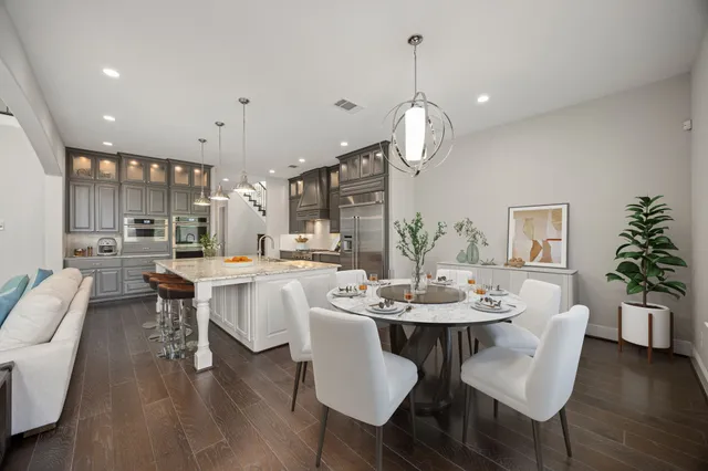 a dining room with wooden floor a chandelier a glass table and chairs