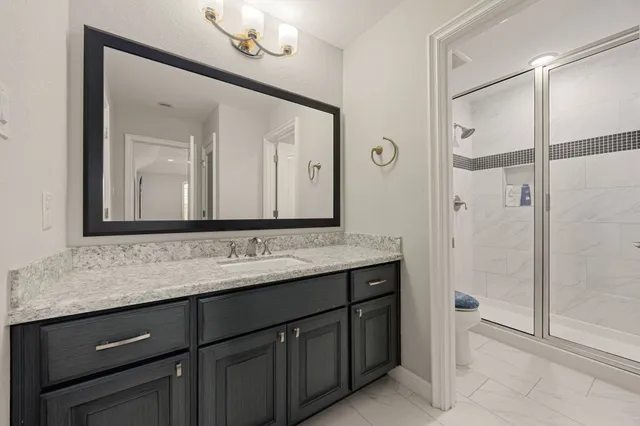 a bathroom with a granite countertop sink vanity and a mirror