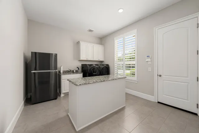 a kitchen with a refrigerator and a stove top oven