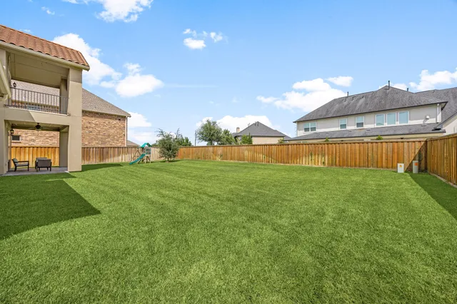 a view of a house with a big yard potted plants and large tree