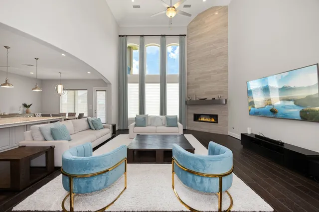 a living room with fireplace furniture and a large window