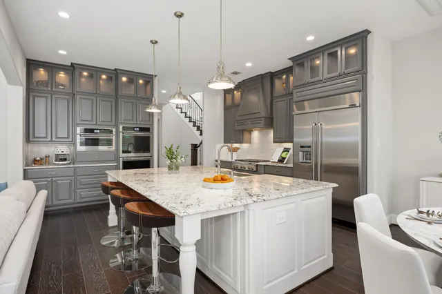 a kitchen with stainless steel appliances granite countertop a sink a stove and a refrigerator