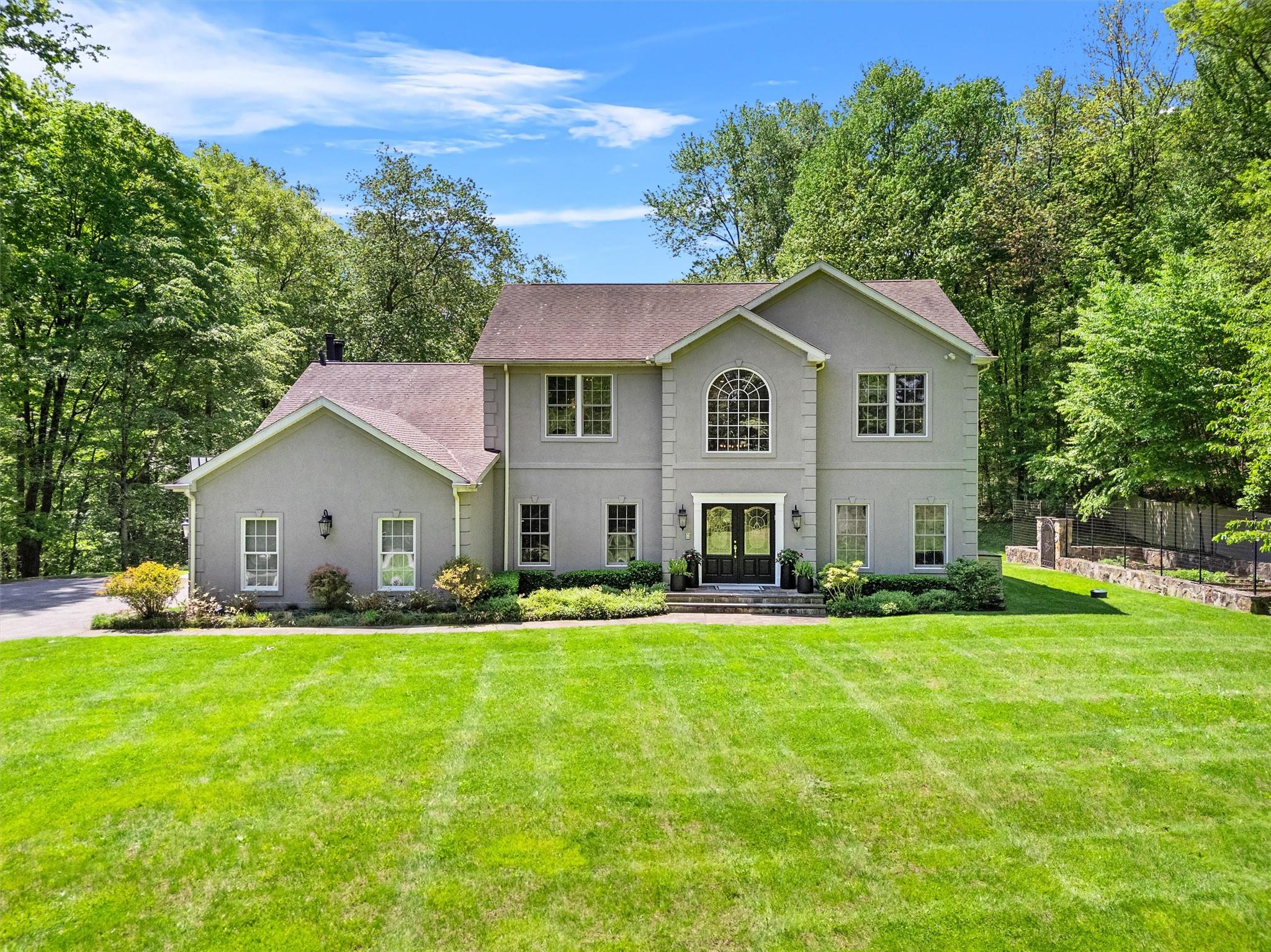 27 Pheasant Run Road Putnam Valley, NY 10579 - Photo 1 of 1 Colonial house featuring stucco siding, a front yard, and french doors.