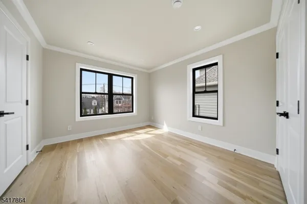 a bedroom with a bed couch and windows