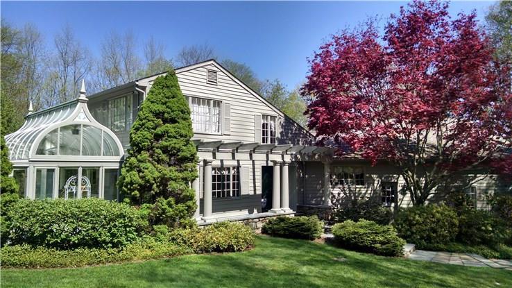 9 Saunders Lane Ridgefield, CT 06877 - Photo 1 of 1 a view of a house with brick walls and a yard with plants and large trees