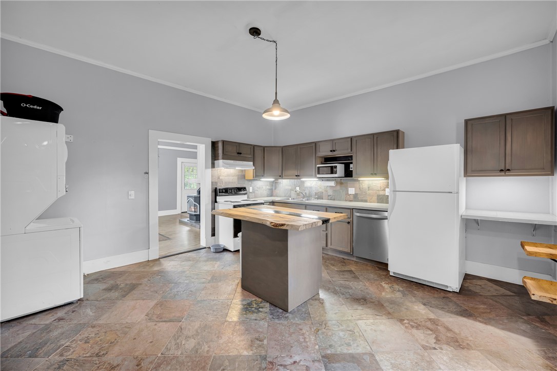 308 Verner Street Walhalla, SC 29691 - Photo 10 of 49 Natural stone flooring underpins a functional kitchen anchored by a wood-topped prep island.