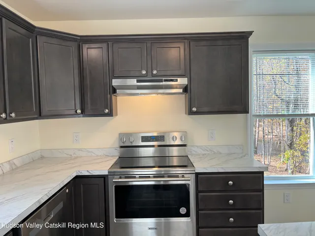 a kitchen with granite countertop a stove and a sink