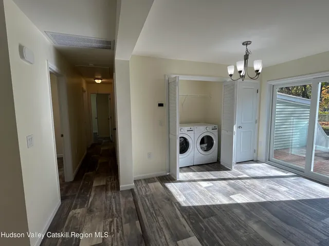 a view of a hallway with wooden floor and chandelier