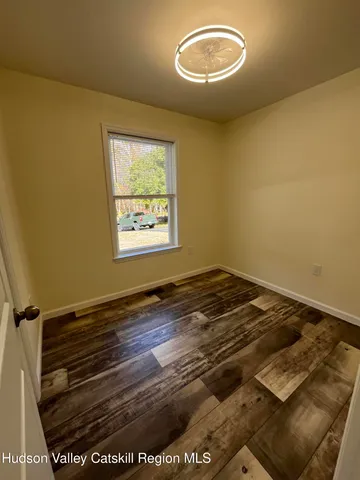 a view of a room with wooden floor and a window