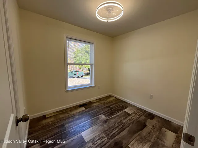 a view of a room with wooden floor and a window