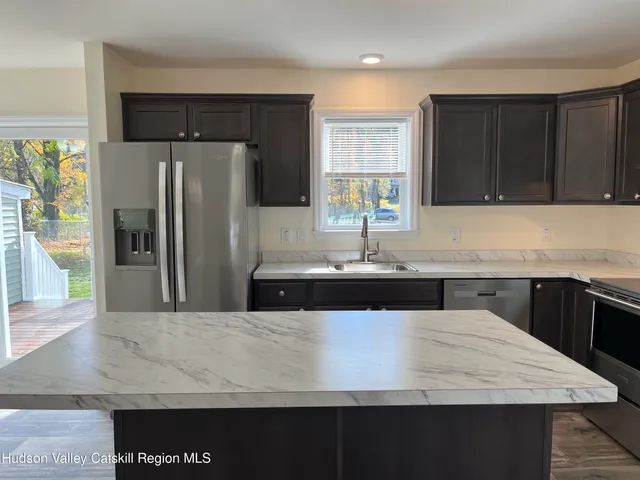 a kitchen with a refrigerator a sink and cabinets
