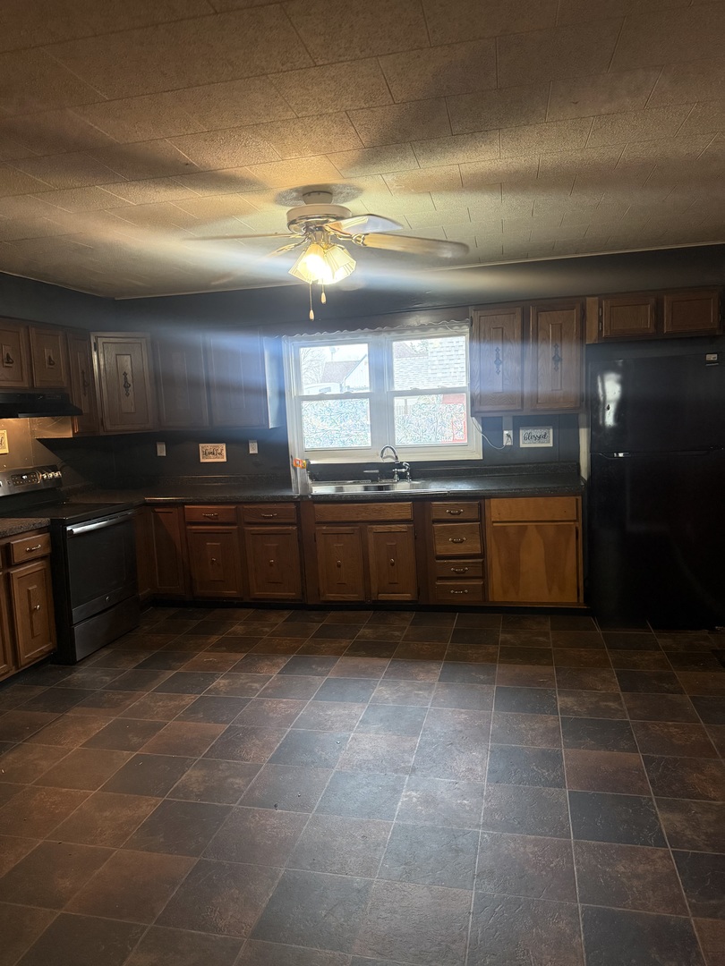 312 East 11th Street Georgetown, IL 61846 - Photo 4 of 25 a kitchen with stainless steel appliances granite countertop a sink and cabinets