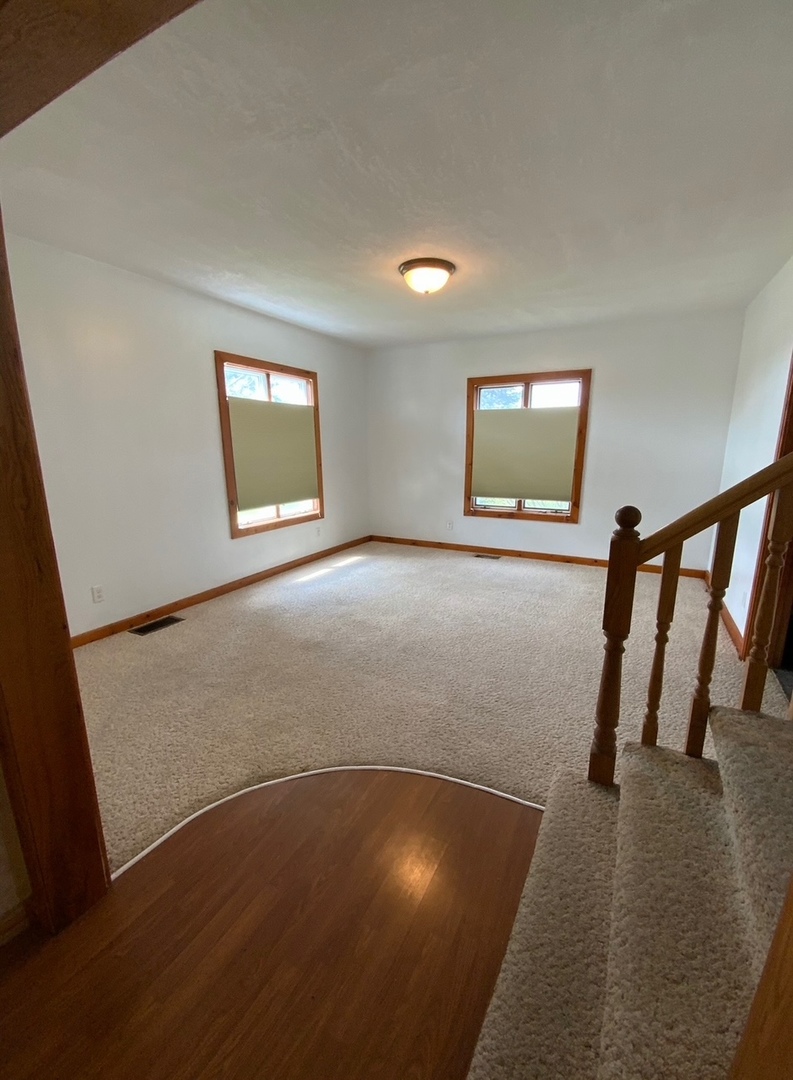 382 Keigwin Road Walnut, IL 61376 - Photo 43 of 49 an empty room with wooden floor and windows
