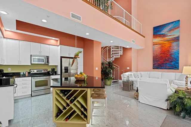 a kitchen with stainless steel appliances kitchen island granite countertop a refrigerator and a stove top oven