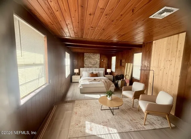 a view of a room with wooden floor and furniture