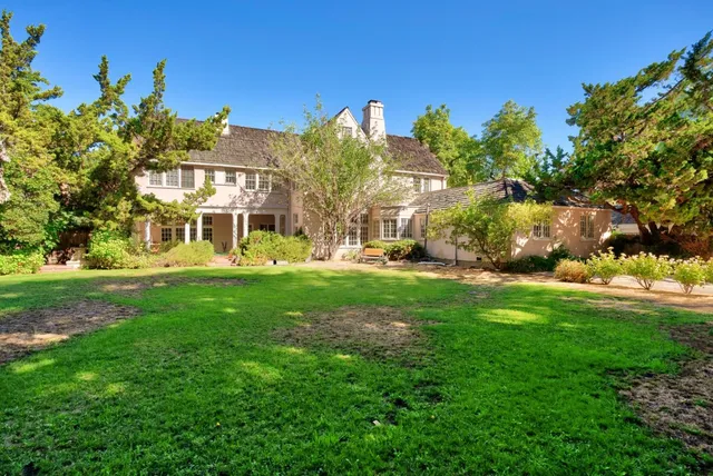a view of green field with trees in the background