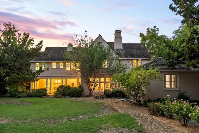 a front view of a house with a yard and trees